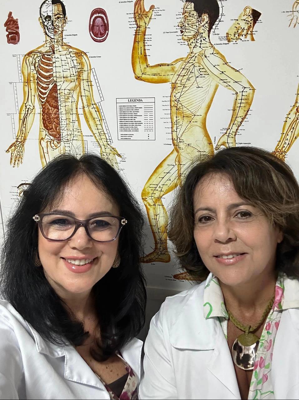 Isabel Maria Martins da Graça à esquerda e Aparecida Queiroz Santos à direita, de jaleco branco, lado a lado.